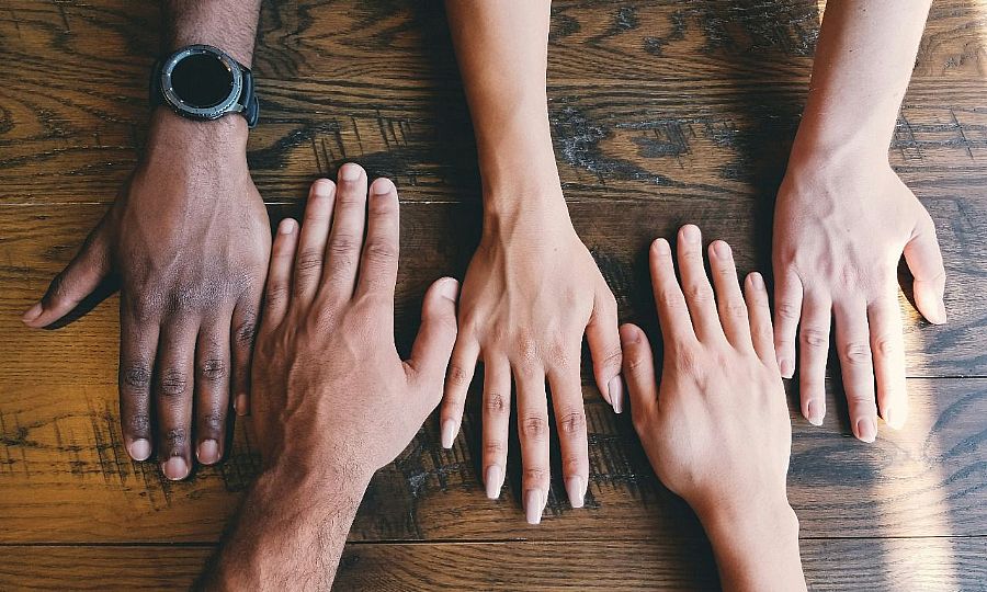 Five hands on a table